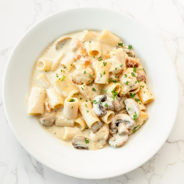 DiCicco's rigatoni pasta with creamy sauce, mushrooms, and chicken, garnished with parsley.
