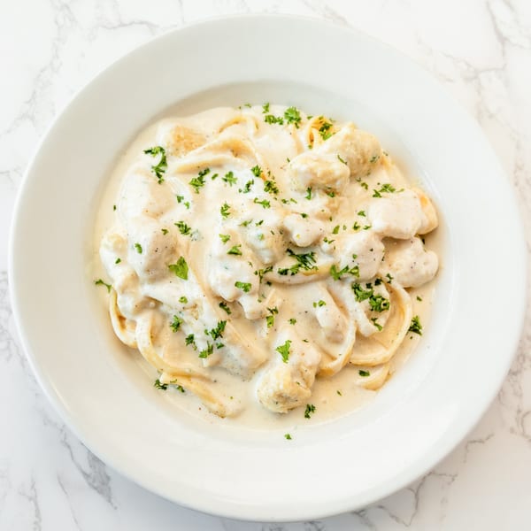Creamy Italian pasta dish with fettuccine and chicken, garnished with fresh parsley.